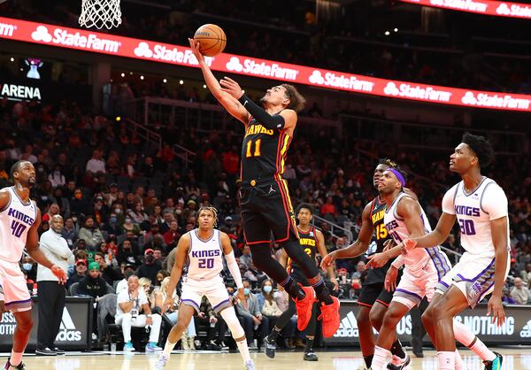 Hawks guard Trae Young soars to the basket for two past a host of Sacramento Kings defenders in a NBA basketball game on Wednesday, Jan. 26, 2022, in Atlanta.   “Curtis Compton / Curtis.Compton@ajc.com”`