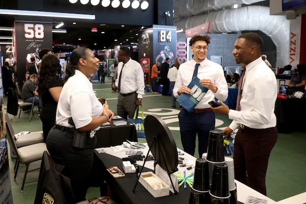 Investigator Detrica Zimmerman (left), with the Cobb County Sheriff’s Office, talks with Army veterans Thomas Evans of Mableton (center) and Gary Ingram of Lilburn during a Veterans Job Fair at Mercedes-Benz Stadium, Thursday, September 29, 2022, in Atlanta. About 300 veterans met with dozens of employers and organizations at the job fair hosted by DAV and RecruitMilitary. (Jason Getz / Jason.Getz@ajc.com)