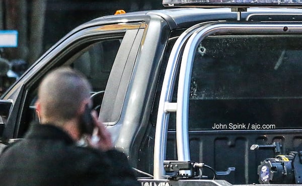 There is a bullet hole in the back windshield of the tow truck. JOHN SPINK / JSPINK@AJC.COM