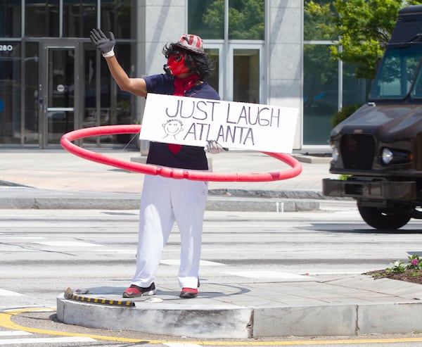 Rick Hunt waves to motorists as they drive down Peachtree Road near Lenox Square mall on Monday, May 4, 2020. STEVE SCHAEFER / SPECIAL TO THE AJC