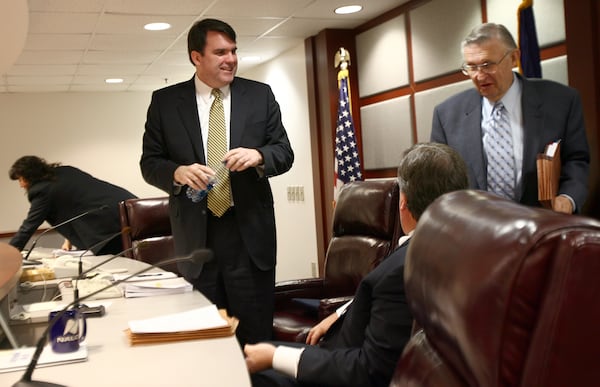 Chuck Eaton (cq), left, the new chairman of the Public Service Commission, talks with now-former commissioners Stan Wise (cq), center, and Doug Everett (cq) after presiding over an administrative session. (BEN GRAY / Staff)