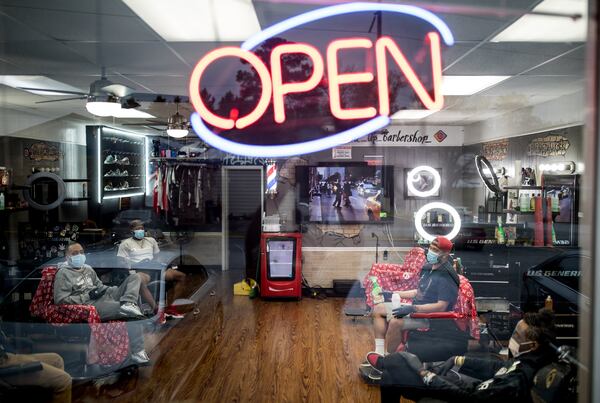 Blessed Up Barbershop Owner Taurean Overall, top right, goes over safety measures to help prevent the spread of Coronavirus when they open back up on April 23, 2020, in Marietta, Ga. Blessed Up will also open up its Acworth and Canton locations after Gov. Kemp is allowing certain businesses reopen for business. BRANDEN CAMP / SPECIAL