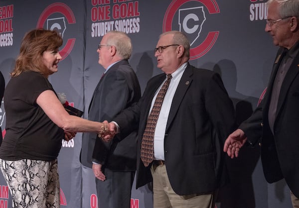 A retiring employee greets Cobb school board member Brad Wheeler.