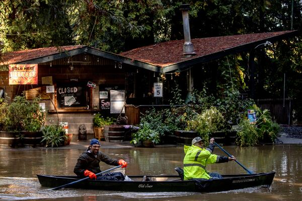 Kevin Ozorkiewicz, left, and neighbor John Phillips row a canoe at the flooded Mirabel RV Park & Campground after a major storm in Forestville, Calif., Sonoma County, Saturday, Nov. 23, 2024. (Stephen Lam/San Francisco Chronicle via AP)