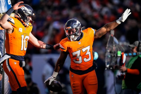 Denver Broncos running back Javonte Williams (33) celebrates his touchdown with quarterback Bo Nix (10) during the first half of an NFL football game against the Atlanta Falcons, Sunday, Nov. 17, 2024, in Denver. (AP Photo/Jack Dempsey)