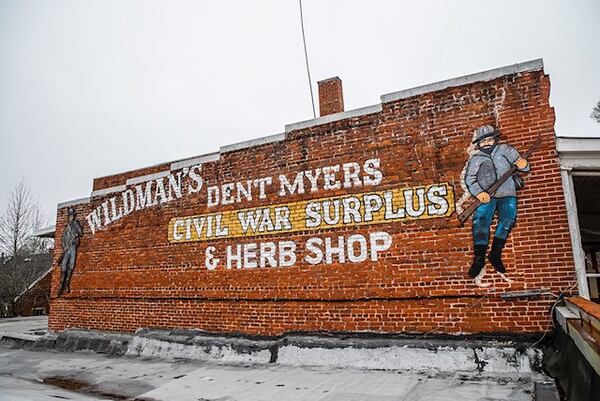 The pre-existing mural at Wildman's Civil War Surplus, a controversial Confederal memorabilia shop in downtown Kennesaw, before it was vandalized by a group of artists/activists this weekend. (Courtesy of INDECLINE)