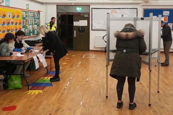 Voters cast their ballots at Delgany National School, County Wicklow, as voters go to the polls for the 2024 General Election in Ireland, Friday Nov. 29, 2024. (Niall Carson/PA via AP)