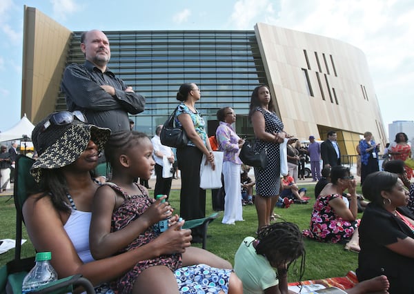 Karen James (left), from Conyers, brought her grandchildren, Faith and Trinity Ladson, to see the ceremony and the museum. The National Center for Civil and Human Rights held its grand opening celebration with a 10 a.m. public ceremony outside in the plaza at Pemberton Place in advance of a noon opening. The ceremony included speeches, and a choir which concluded the ceremony with an emotional performance of "We Shall Overcome." BOB ANDRES / BANDRES@AJC.COM