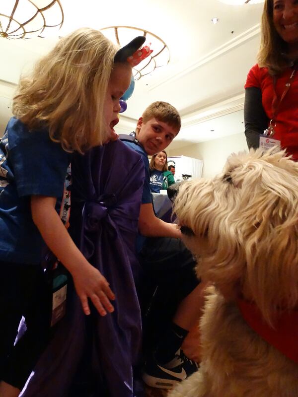 Comfort dog Crosby loves to shake hands with anybody. He has Leslie entranced. CREDIT: Rodney Ho/ rho@ajc.com