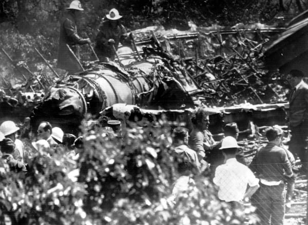 June 3, 1962 - After flames are extinguished, two firemen climb over one of jet engines. The Boeing 707 just missed a house (extreme right) in Villeneuve Le Roi, near Orly Airfield.