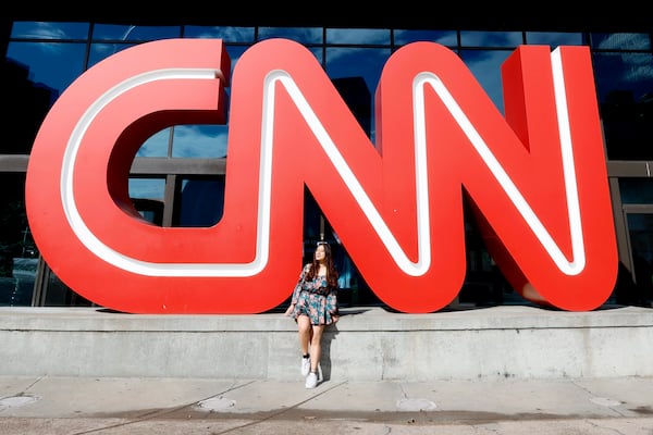 THE OLD LOGO: Alexandra Arlos, who is visiting from Peru, poses with the CNN logo outside the CNN Center on Thursday, January 19, 2023. The logo was removed in 2024 after CNN moved to Midtown. CNN Center is now called The Center. Miguel Martinez / miguel.martinezjimenez@ajc.com