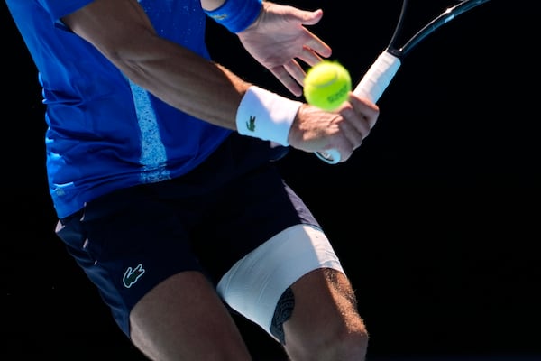 Novak Djokovic of Serbia plays a backhand return to Alexander Zverev of Germany during their semifinal match at the Australian Open tennis championship in Melbourne, Australia, Friday, Jan. 24, 2025. (AP Photo/Ng Han Guan)