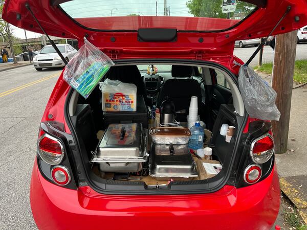 A vendor sells hot breakfast items out of her car to migrants waiting in line to check in with ICE agents in downtown Atlanta on Tuesday, April 16, 2024. (Lautaro Grinspan)