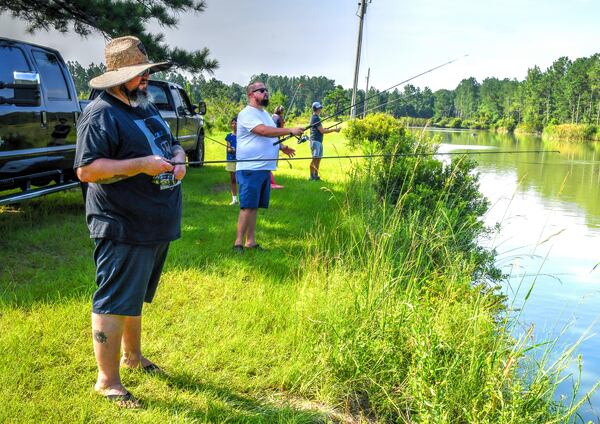 Tim Lensch (from front), Eric Miller and Zack Gowen fish for catfish at Satilla Ponds. Chris Hunt for The Atlanta Journal-Constitution 