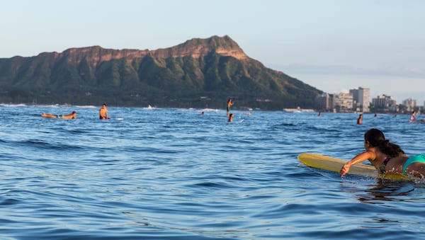 A surfer floats off of Waikiki. (Tor Johnson/Hawaii Tourism Authority)