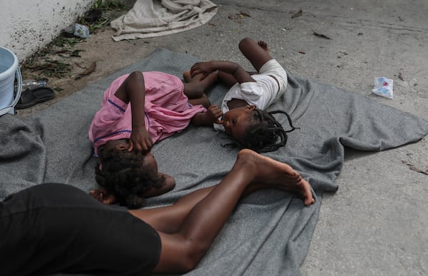 Children sleep on the floor at a school where residents of the Nazon neighborhood displaced by gang violence have sought refuge, in Port-au-Prince, Haiti, Thursday, Nov. 14, 2024. (AP Photo/Odelyn Joseph)