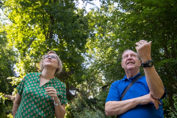 Steve Rushing and his neighbor Erin Braden watch a Red-tailed Hawk as it flies high above the trees in his driveway at his residence in Decatur, Tuesday, June 15, 2021. (Alyssa Pointer / Alyssa.Pointer@ajc.com)