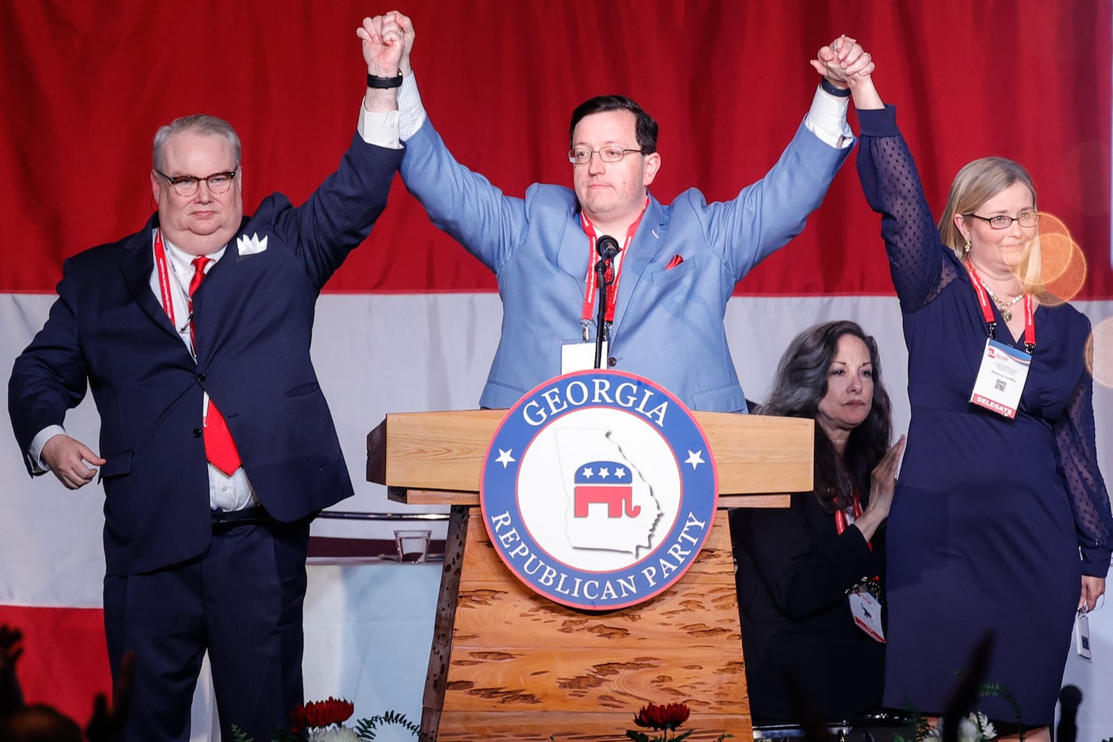 Georgia Republican Party Chairman candidates Dennis Fucch (left) and Rebecca Yardley (right) hold hands with newly appointed chairman Joshua McKoon (center) during the GOP Convention on Saturday, June 10, 2023. (Natrice Miller/natrice.miller@ajc.com)