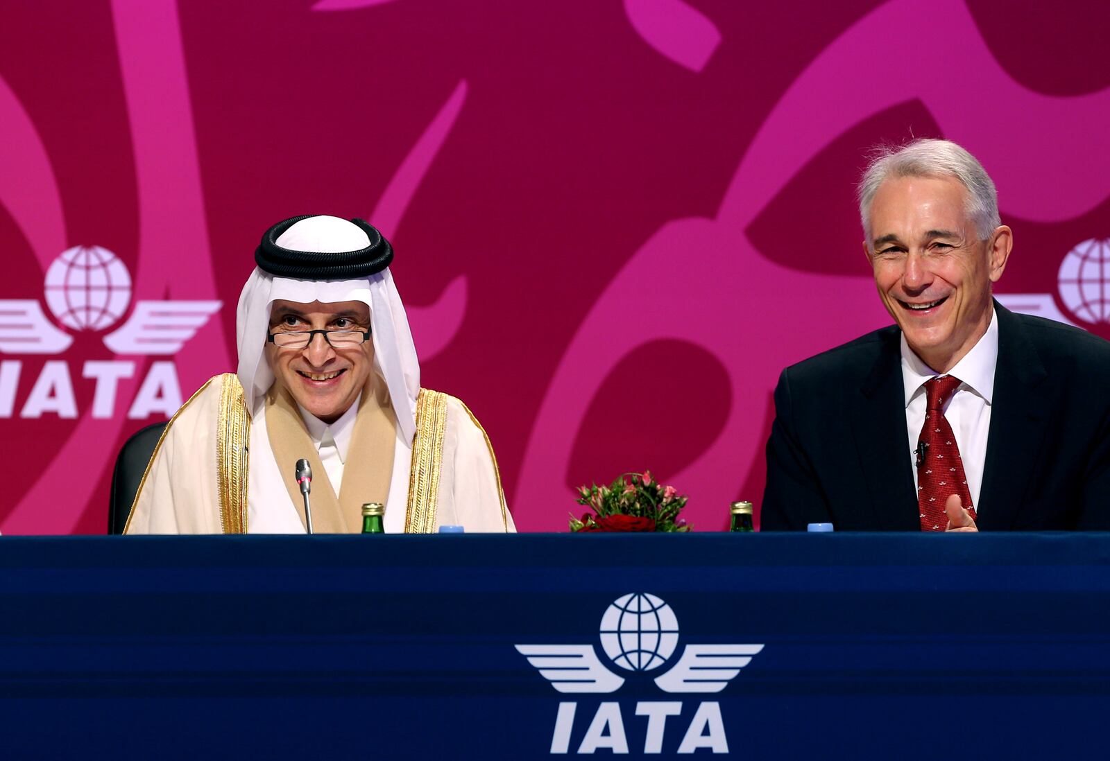 Qatar Airways Chief Executive Officer Akbar Al Baker, left, and International Air Transport Association director Tony Tyler laugh during the the IATA's annual meeting held this year in Doha, Qatar, Monday, June 2, 2014. Tyler says the group will prepare a draft of new recommendations in September to improve global tracking capabilities in the aftermath of the disappearance of Malaysia Airlines Flight 370. (AP Photo/Osama Faisal)