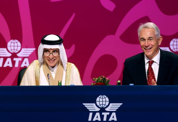 Qatar Airways Chief Executive Officer Akbar Al Baker, left, and International Air Transport Association director Tony Tyler laugh during the the IATA's annual meeting held this year in Doha, Qatar, Monday, June 2, 2014. Tyler says the group will prepare a draft of new recommendations in September to improve global tracking capabilities in the aftermath of the disappearance of Malaysia Airlines Flight 370. (AP Photo/Osama Faisal)