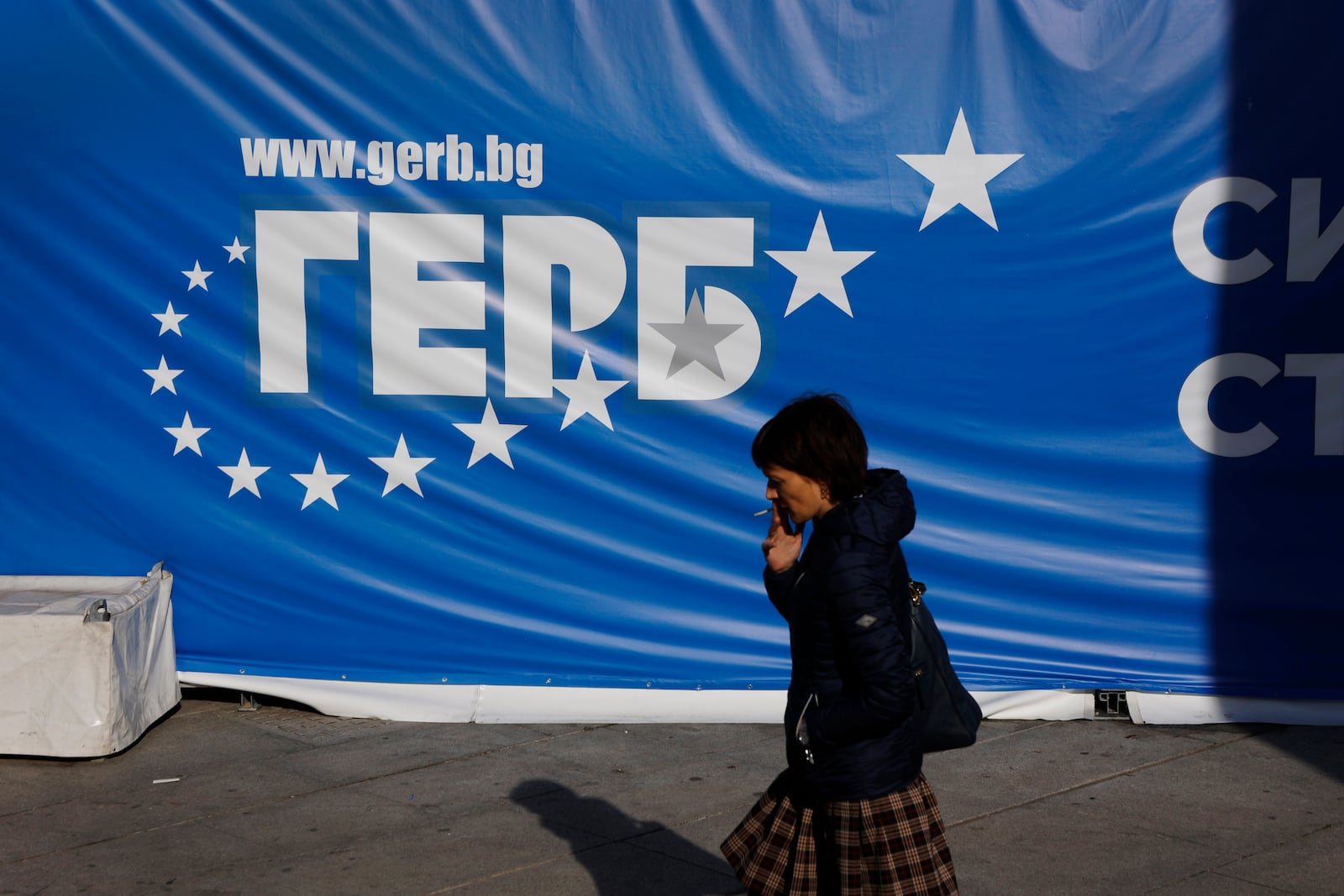 A woman walks in front of a GERB party poster Thursday, Oct. 24, 2024, in Sofia, as Bulgarians are called to cast ballots on Sunday in the seventh general elections in just over three years, as their country is facing growing political instability that might further enhance the popularity of pro-Russian and far-right groups. (AP Photo/Valentina Petrova)