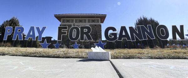 A box of tissues sits on the sidewalk full of messages and in front of a large sign to "Pray for Gannon" at the entrance for Lorson Ranch, near Colorado Springs, Colorado.