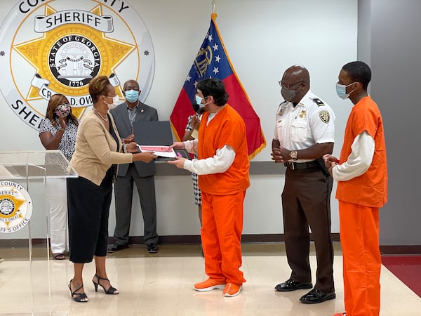 Ebony White, a program manager at the Urban League of Greater Atlanta, presents a Cobb County inmate with his certificate for completing the jail's Young Fathers program. (Photos provided/Cobb County Sheriff’s Office)