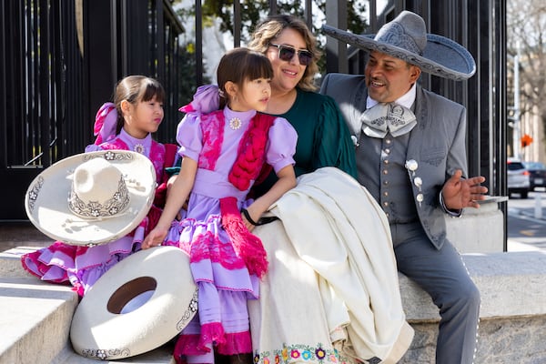 From left: Daniela, 7, Denisse, 6, Monica and Mauricio Echeveste, part of equestrian group Union Charreria Associations of Georgia and Tennessee, sit outside the state Capitol on Wednesday.