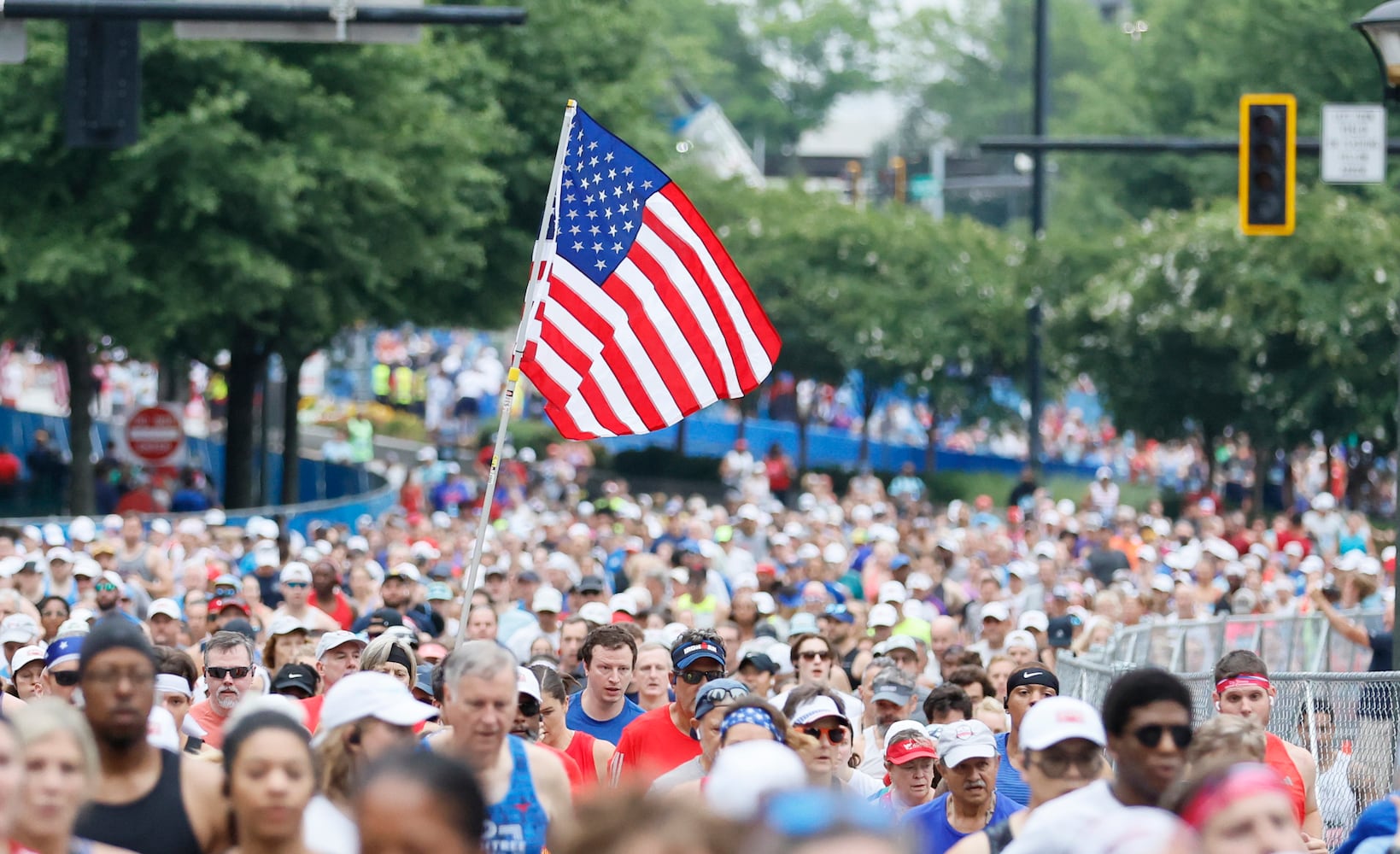 Runners along Peachtree Street during the 54th running of the Atlanta Journal-Constitution Peachtree Road Race in Atlanta on Atlanta on Tuesday, July 4th, 2023.   (Miguel Martinez / Miguel.Martinezjimenez@ajc.com)