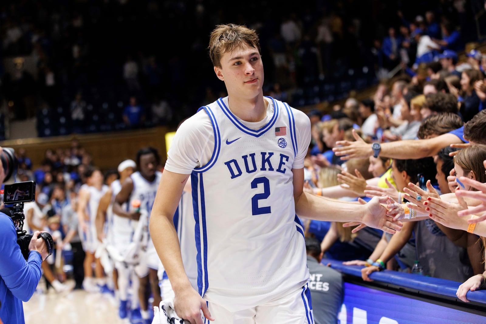 Duke's Cooper Flagg (2) high-fives fans after NCAA college basketball exhibition game against Lincoln in Durham, N.C., Saturday, Oct. 19, 2024. (AP Photo/Ben McKeown)