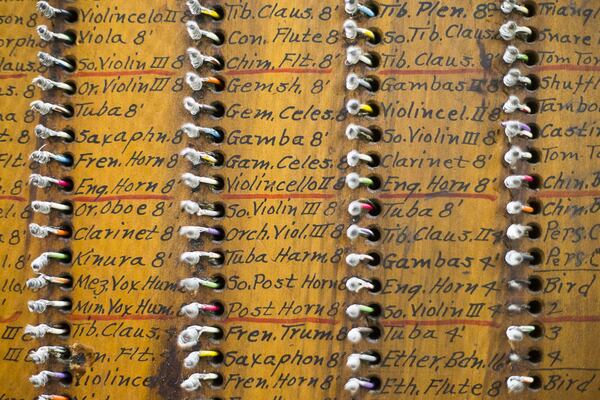 Handwritten notes are displayed along the wood junction board on the back of Mighty Mo. The junction board is a traditional way to wire the console to the pipe chambers. ALYSSA POINTER/ALYSSA.POINTER@AJC.COM