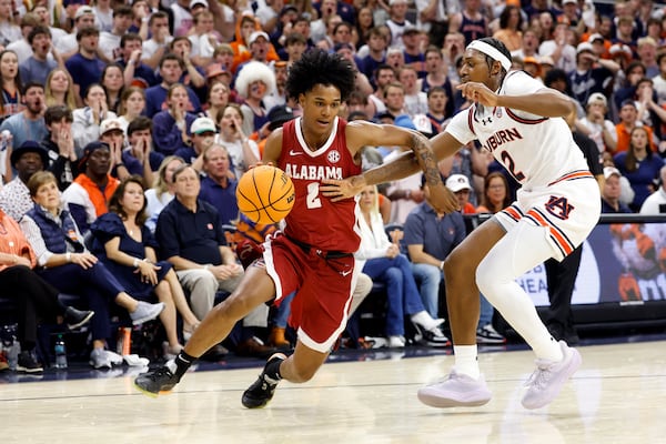 Alabama guard Aden Holloway (2) drives the baseline around Auburn guard Denver Jones (2) during the first half of an NCAA college basketball game, Saturday, March 8, 2025, in Auburn, Ala. (AP Photo/Butch Dill)