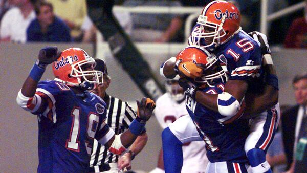 Reidel Anthony leaps into the arms of Tremayne Allen as they and Ike Hilliard (19) celebrate Anthony's fourth quarter touchdown in the SEC Championship game won by Florida 45-30 in the Georgia Dome on Dec. 7, 1996. 