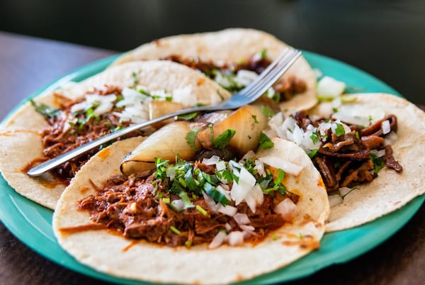 A plate of four tacos from El Rey Del Taco, including goat barbacoa (foreground) and buche, or pig stomach (background). CONTRIBUTED BY HENRI HOLLIS