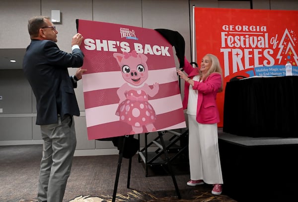 Stan Hall (left), CEO of the Gas South District, and Angie Ulibarri, executive director of the Georgia Festival of Trees, reintroduce the Pink Pig during a news conference on Saturday, July 27, 2024, in Duluth. (Hyosub Shin/AJC 2024)