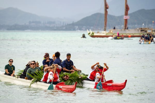 Kaneohe Canoe Club paddles the crew members of Hokulea before Hokulea's 50th birthday commemoration at Kualoa Regional Park, Saturday, March 8, 2025, in Kaneohe, Hawaii. (AP Photo/Mengshin Lin)