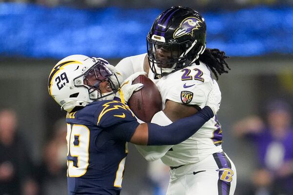 Baltimore Ravens running back Derrick Henry (22) is tackled by Los Angeles Chargers cornerback Tarheeb Still (29) during the second half of an NFL football game Monday, Nov. 25, 2024, in Inglewood, Calif. (AP Photo/Eric Thayer)