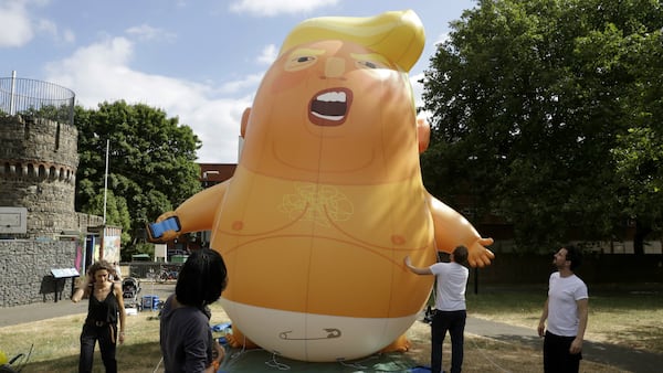 In this photo taken on Tuesday, July 10, 2018, a six-meter high cartoon baby blimp of U.S. President Donald Trump stands inflated during a practice session in Bingfield Park, north London. Trump will get the red carpet treatment on his brief visit to England that begins Thursday: Military bands at a gala dinner, lunch with the prime minister at her country place, then tea with the queen at Windsor Castle before flying off to one of his golf clubs in Scotland. But trip planners may go out of their way to shield Trump from viewing another aspect of the greeting: an oversize balloon depicting the president as an angry baby in a diaper that will be flown from Parliament Square during what are expected to be massive gatherings of protesters opposed to Trump's presence.