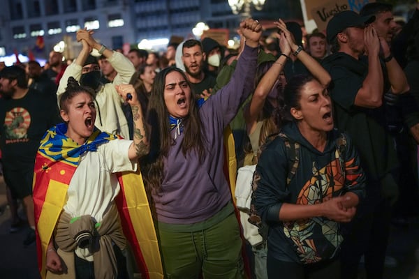 Demonstrators shout slogans as they gather for a protest organized by social and civic groups, denouncing the handling of recent flooding under the slogan "Mazón, Resign," aimed at the president of the regional government Carlos Mazon, in Valencia, Spain, Saturday, Nov. 9, 2024. (AP Photo/Emilio Morenatti)