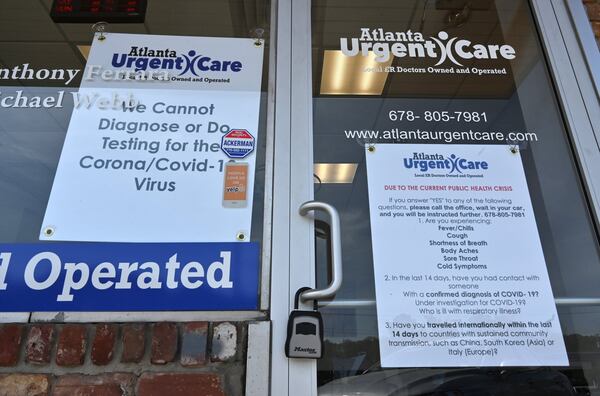 Signs posted outside Atlanta Urgent Care in Atlanta instructs patients to not come inside if they have cold or flu-like symptoms. (Hyosub Shin / Hyosub.Shin@ajc.com)