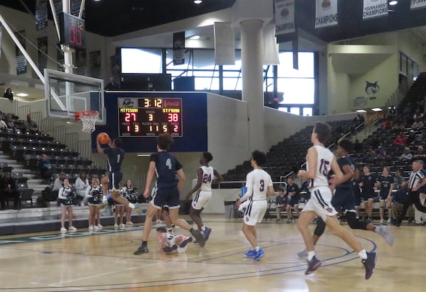 Dwon Odom of St. Francis goes up for a two-handed slam as a Mount Pisgah defender lies watching on the ground in their Class A Private semifinal game Friday, Feb. 28, 2020 at Georgia College and State University's Centennial Center in Milledgeville. (Adam Krohn, for the AJC)