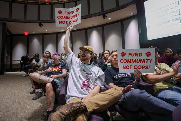 Protestors hold a “Fund Community Not Cops!,” sign during the public comment portion of the Atlanta City Council ahead of the final vote to approve legislation to fund the training center at Atlanta City Hall, on Monday, June 5, 2023, in Atlanta. (Jason Getz / Jason.Getz@ajc.com)