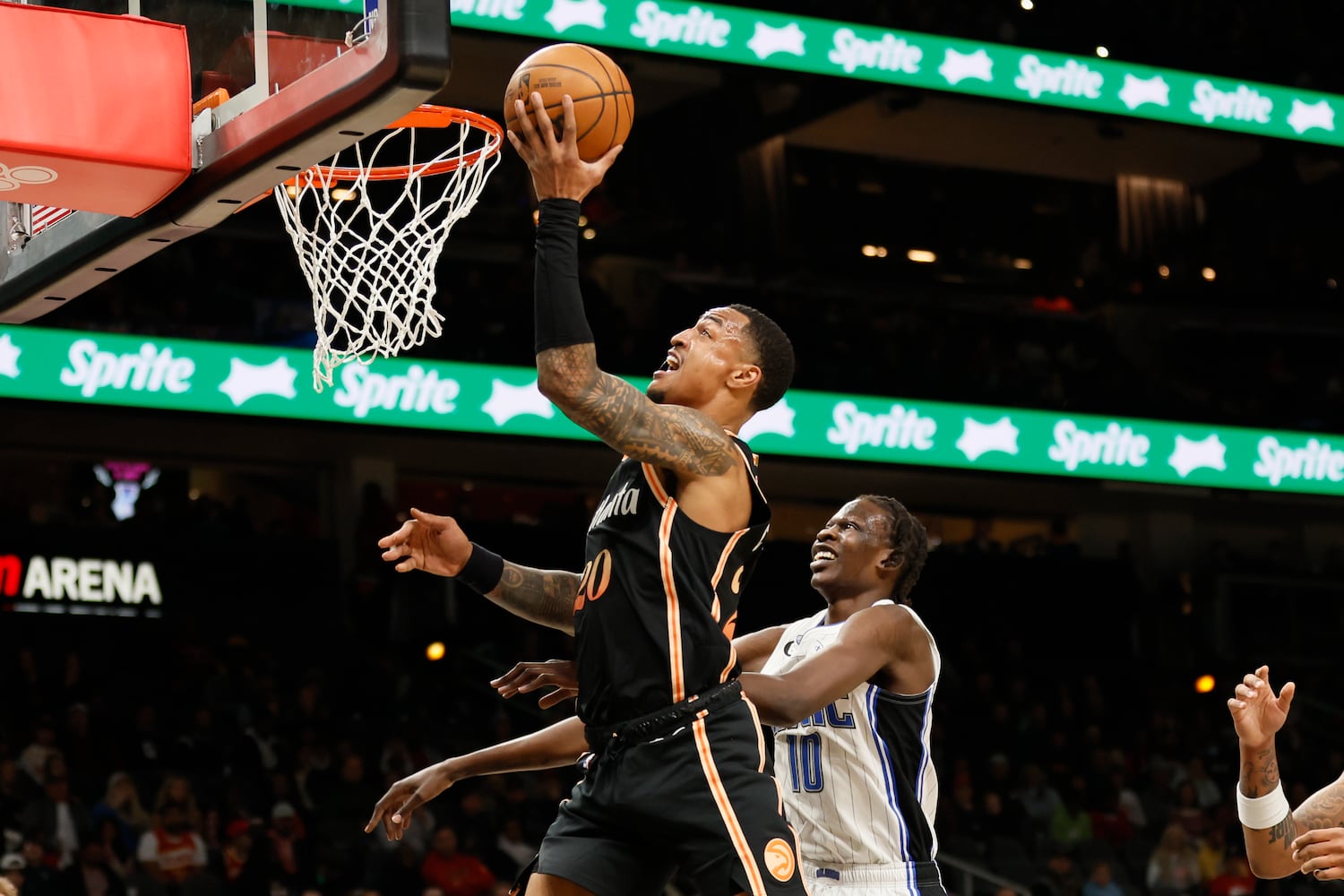 Hawks forward John Collins goes up for a layup against Magic center Bol Bol during the first half Monday night in Atlanta. (Miguel Martinez / miguel.martinezjimenez@ajc.com)