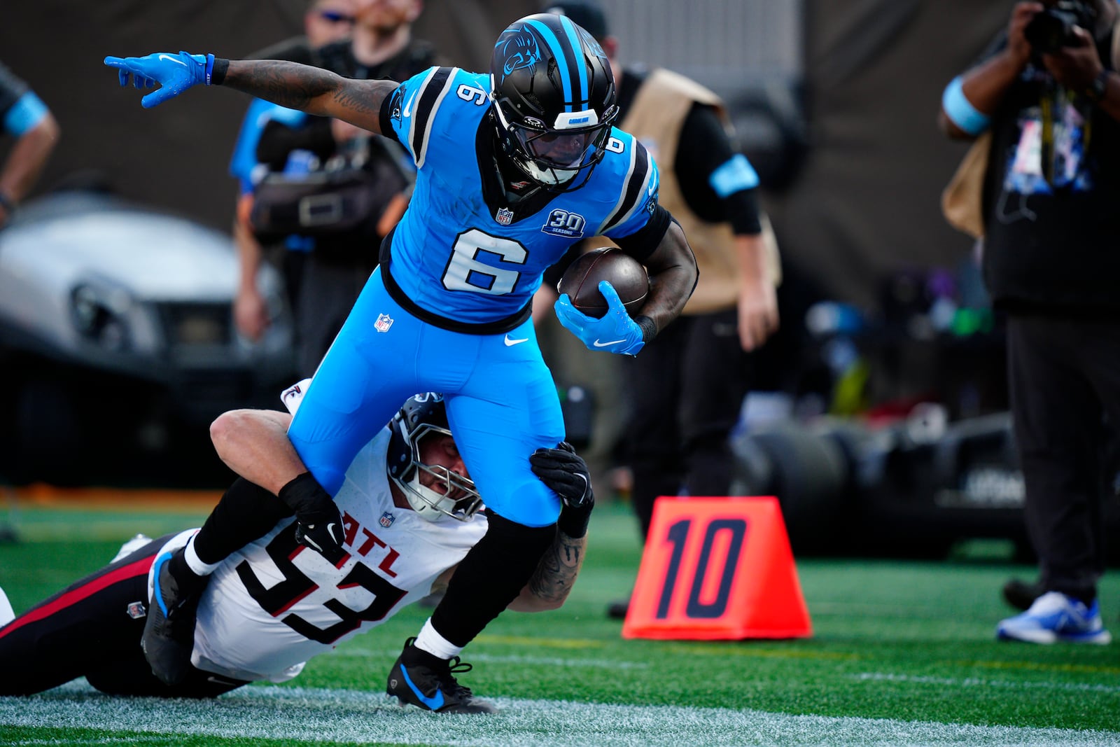 Atlanta Falcons linebacker Nate Landman (53) tackles Carolina Panthers running back Miles Sanders (6) in the first half of an NFL football game in Charlotte, N.C., Sunday, Oct. 13, 2024. (AP Photo/Jacob Kupferman)