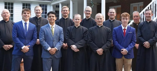 Scott Reilly (fourth from right), Matthew Kaderabek (sixth from right) and Edward Mcilmail (seventh from right) are part of the Legionaries of Christ community in Cumming, whose home was destroyed in a fire this month.