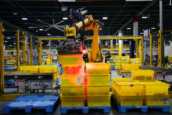 An automated arm robot is seen moving bins full of packages at the Transfer Out Station on Monday, December 2, 2024 at the Amazon distribution center in Stone Mountain.
(Miguel Martinez / AJC)