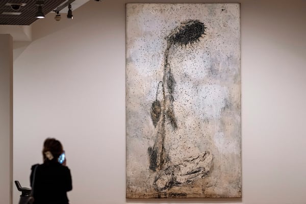 A woman takes an image of Sol Invictus (Unconquered Sun) during a press preview of the Anselm Kiefer exhibit in both the Van Gogh Museum and the Stedelijk Museum in Amsterdam, Netherlands, Wednesday, March 5, 2025. (AP Photo/Peter Dejong)