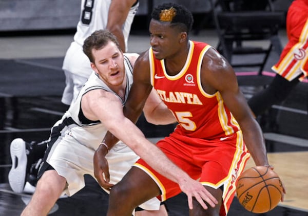 Atlanta Hawks' Clint Capela, right, drives against San Antonio Spurs' Jakob Poeltl during the first half of an NBA basketball game Thursday, April 1, 2021, in San Antonio. (AP Photo/Darren Abate)