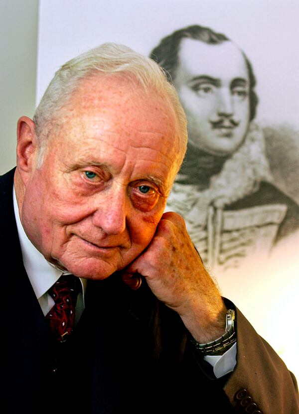 FILE - In this June 23, 2005 file photo, Dr. James C. Metts Jr., the Chatham County coroner, poses in front of a portrait of Brig. Gen. Casimir Pulaski in Savannah, Ga. Metts whose four decades as coroner in the Savannah area earned him a part in the bestselling book "Midnight in the Garden of Good and Evil," died Monday, Jan. 20, 2020, at his Savannah home, where he had been under hospice care. He was 88. (AP Photo/Stephen Morton, File)