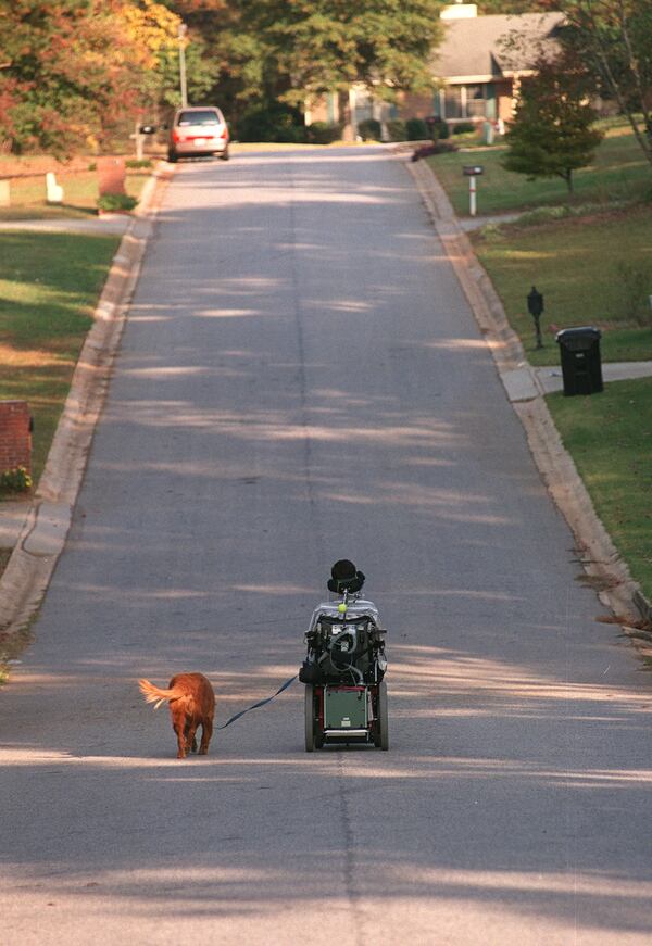  David Jayne takes his dog, Red, for a walk around the neighborhood. His disease has shut down his body to the point that a ventilator does his breathing. The only part of his body still intact is his brain, which is not affected by the disease. (RICH ADDICKS/STAFF)